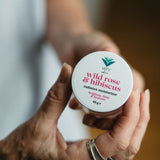 Hand holding a container of 'wild rose & hibiscus' moisturizer by Verv.